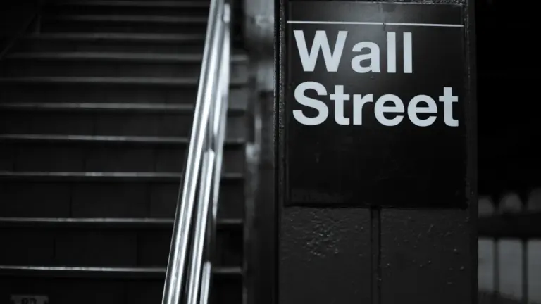 Czarno-białe zdjęcie znaku ulicznego Wall Street w Nowym Jorku, symbolu wielkiego kryzysu finansowego.