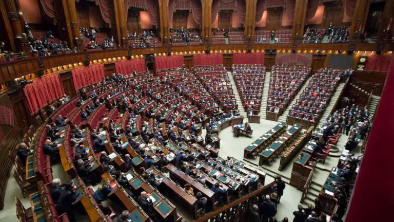 Sala obrad parlamentu z czerwonymi fotelami podczas ważnego posiedzenia ustawodawczego
