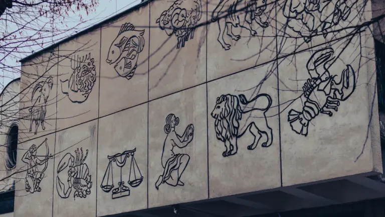 Zodiakalne znaki na fasadzie budynku w Krakowie, idealna ilustracja do artykułu o horoskopach.
