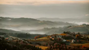 Jesienny krajobraz z zamglonymi dolinami i widokiem na miejscowość w Polsce