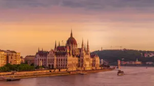Budynek Parlamentu w Budapeszcie nad Dunajem w promieniach zachodzącego słońca.