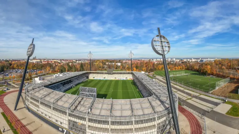 Panoramiczny widok na nowoczesny stadion piłkarski w jesiennej scenerii z lotu ptaka.